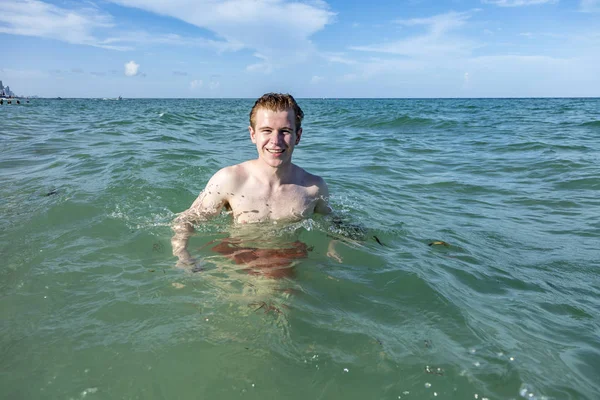 Teenage boy enjoys swimming in the ocean — Stock Photo, Image