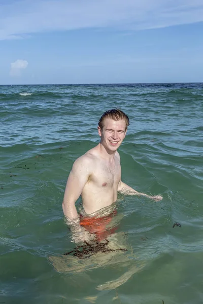 Teenage boy enjoys swimming in the ocean — Stock Photo, Image