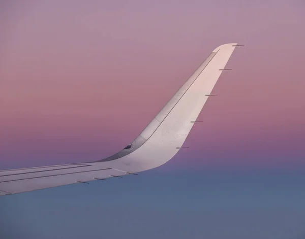 Sonne am Flügel eines Flugzeugs, das im Sonnenaufgang fliegt — Stockfoto