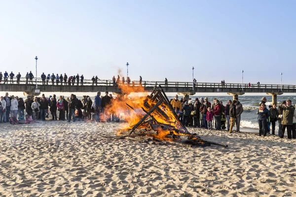 La gente guarda il fuoco pasquale sulla spiaggia — Foto Stock