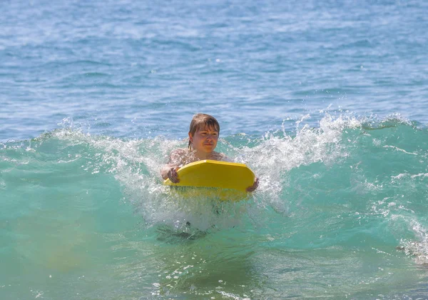 Chłopiec ma fun surfing w fale — Zdjęcie stockowe