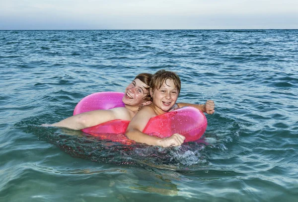 Bröder i en simtur ring har kul i havet — Stockfoto