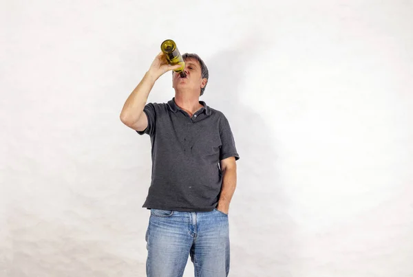 Man drinks alcohol out of a bottle — Stock Photo, Image