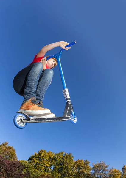 Chłopiec, skoki z jego skuter w skate parku — Zdjęcie stockowe