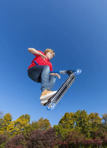 Chłopiec, skoki z jego skuter w skate parku — Zdjęcie stockowe