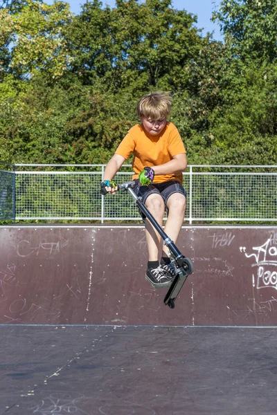 Мальчик с удовольствием катается на самокате в скейт-парке — стоковое фото