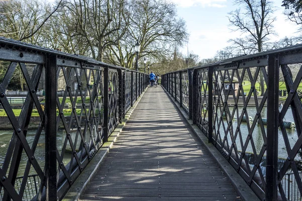 People crossing the river cam at an old iron pedestrian bridge — Stock Photo, Image