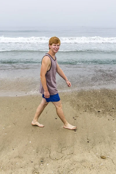 吸引年轻十几岁的男孩走在沙滩上 — 图库照片