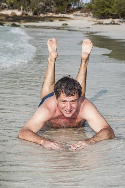 Hombre en traje de baño está tirado en la playa —  Fotos de Stock
