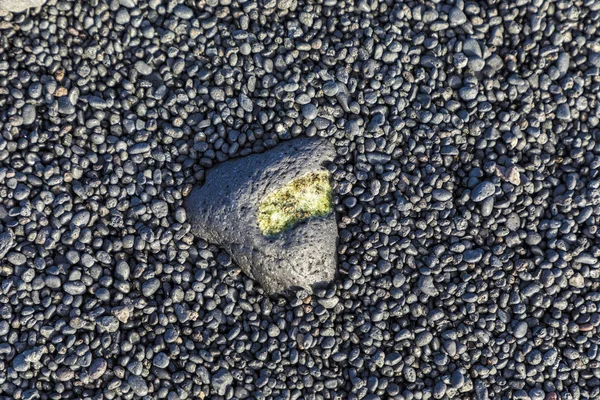 Olivine gemstone também chamado peridot na praia vulcânica — Fotografia de Stock