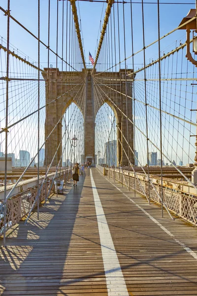 Люди пересекают знаменитый Бруклинский мост в Нью-Йорке — стоковое фото