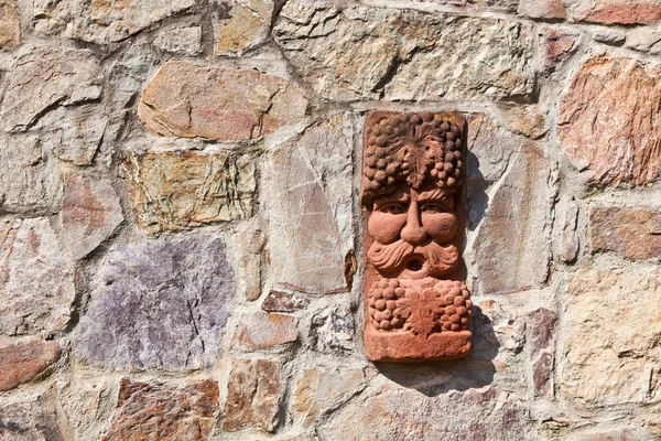 Stará středověká kamenná zeď s tváří baccus, Bůh vinařství — Stock fotografie