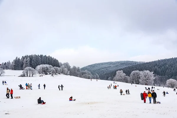 Les enfants patinent à une piste de luge en hiver sur la neige . — Photo