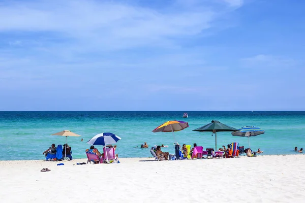 People enjoy the sand and rest under an umbrella at the beautifu — Stock Photo, Image