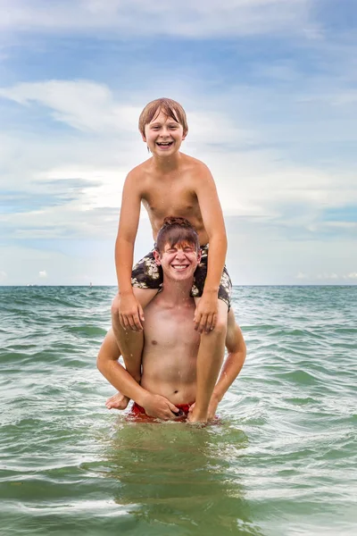 Chłopcy świetnie się bawią w piękne czyste morze — Zdjęcie stockowe