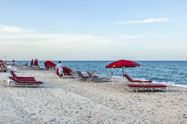 Гостиничный мальчик с красными диванами на южном пляже в конце — стоковое фото