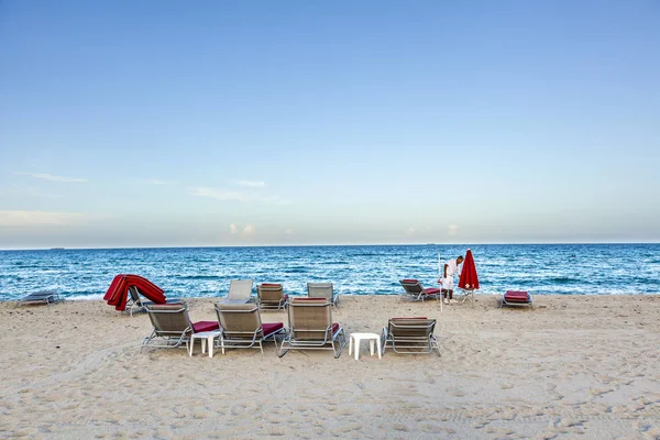 Hotel boy shromažďuje červené pohovky na Jižní pláži na konci — Stock fotografie