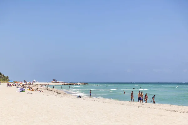 Tourrists sunbath, swim and play on South Beach in Miami Beach, F — стоковое фото