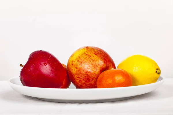 Frutas frescas mezcladas en un plato blanco —  Fotos de Stock