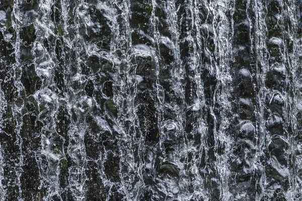 Água corrente em uma cachoeira dá um fundo harmônico — Fotografia de Stock