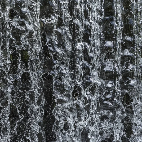 Flödande vatten vid ett vattenfall ger en harmonisk bakgrund — Stockfoto