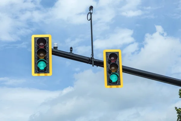 Grönt trafikljus på hängande lampa under himmel — Stockfoto
