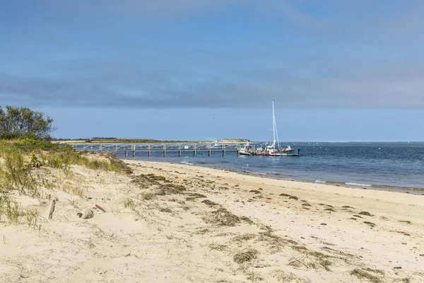 Vackra stranden på ön Cape Cod med brygga och segelbåt på Ch — Stockfoto