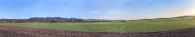 panoramic view of field in wintertime in Thuringia clipart