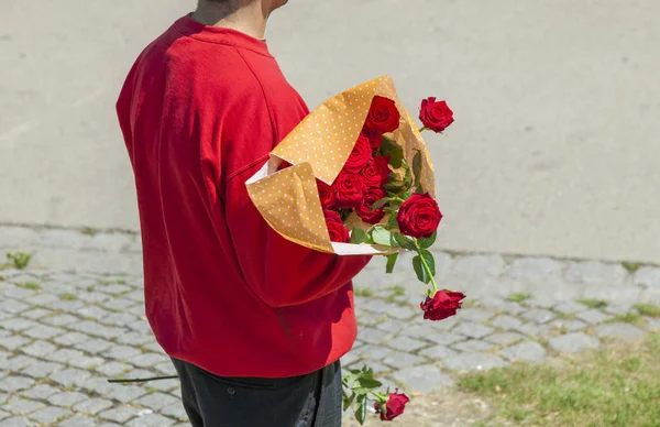 Ο άνθρωπος διαθέτει κόκκινα τριαντάφυλλα ως παρόντες για μια γυναίκα — Φωτογραφία Αρχείου
