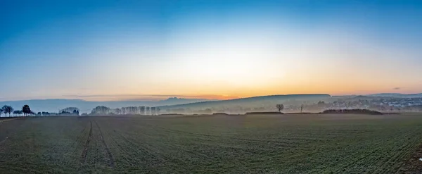 Pôr do sol cênico na paisagem rural com campo — Fotografia de Stock