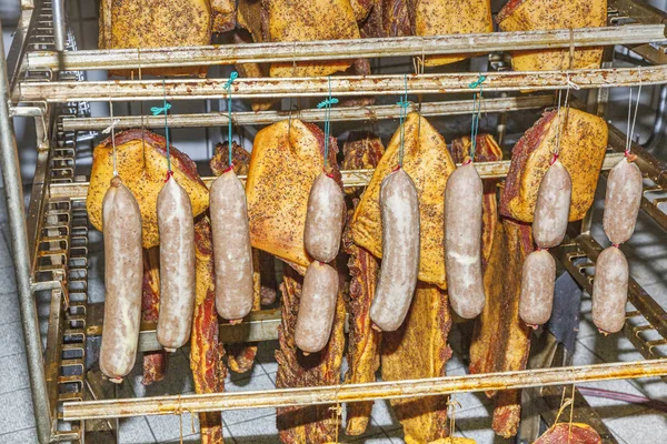 Kött och korv som hänger i ett torkställ efter beredning och — Stockfoto