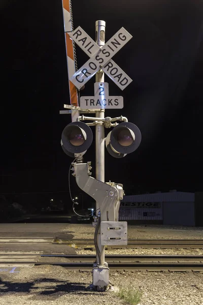Attraversamento ferroviario notturno con cartello — Foto Stock