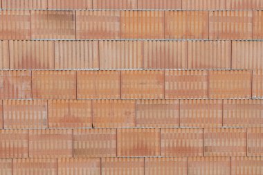 Arkaplan olarak inşaat halindeki bir evin katı kırmızı tuğla duvarı