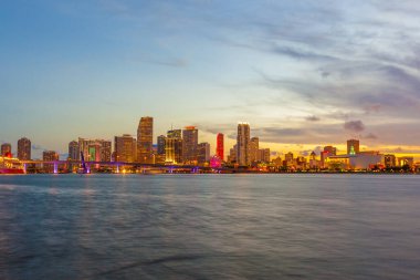 Miami şehir manzarası panorama ile kentsel gökdelenler ve köprüden denize ile yansıma alacakaranlıkta