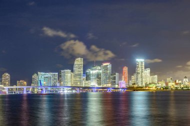 Miami şehir manzarası panorama ile kentsel gökdelenler ve köprüden denize ile yansıma alacakaranlıkta