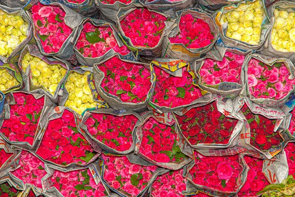 red and yellow roses packed in newspaper at the flower market Pak Khlong Talat in CHinatown of Bangkok, Thailand