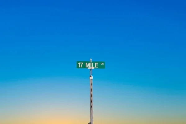 サンセットライトのモントレー近くのペブルビーチで緑の通り標識17マイルドライブ — ストック写真