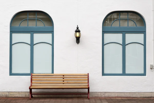 Outdoor bench with white wall — Stock Photo, Image