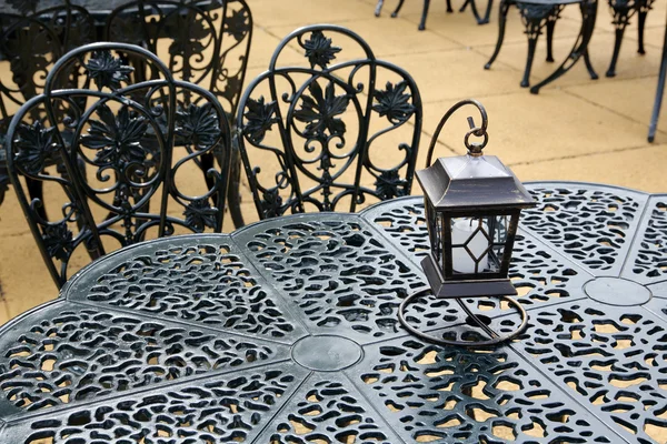 Vintage lantern with chairs and table — Stock Photo, Image