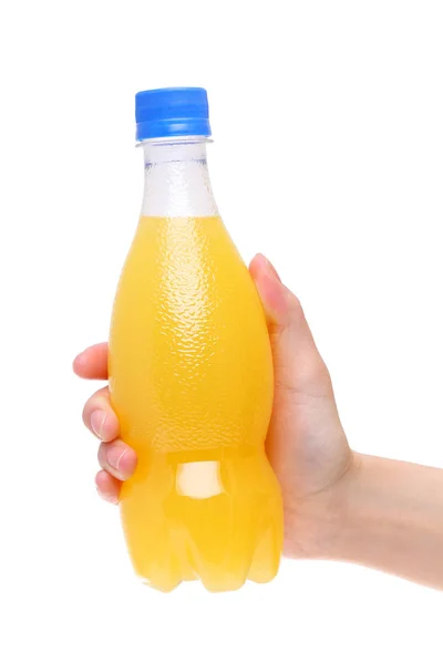 Hand som håller plast flaska juice — Stockfoto