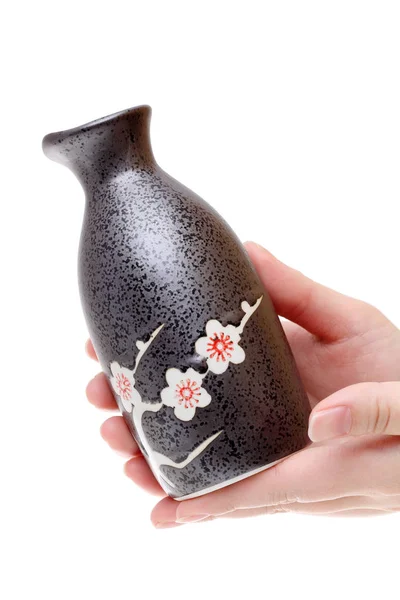 Mão segurando garrafa saquê japonês — Fotografia de Stock