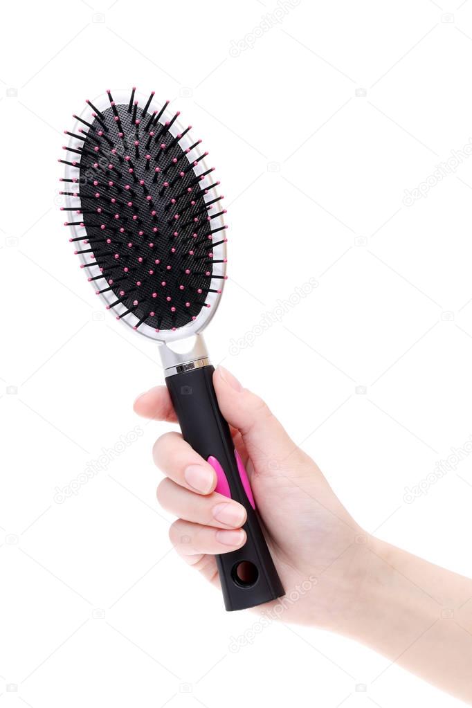 Hand holding plastic hairbrush 