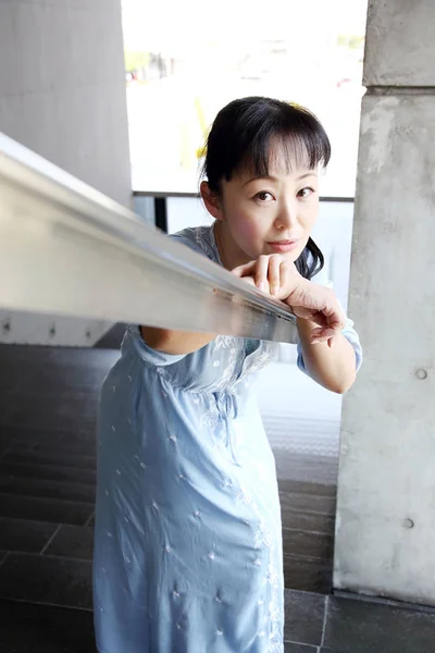 Mujer japonesa apoyada en la barandilla de la escalera — Foto de Stock