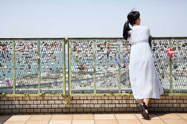 Young beautiful woman leans on fence — Stock Photo, Image
