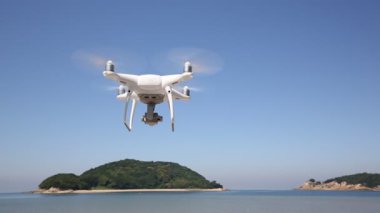 Kıyı ve mavi gökyüzü ile havada uçan uçak beyaz uzaktan kumandalı