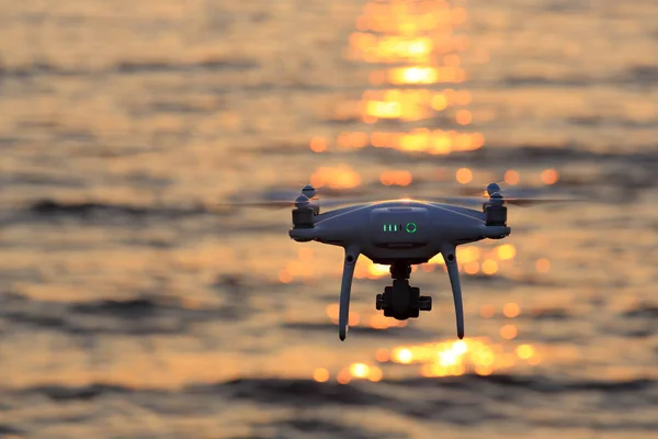 Drone teledirigido que vuela la luz del sol del brillo en el mar —  Fotos de Stock