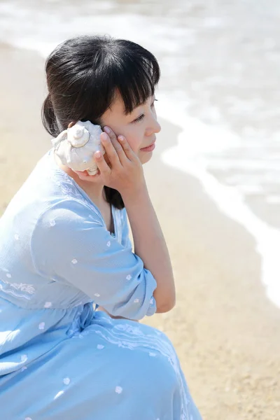 Jovem japonês mulher ouvindo concha — Fotografia de Stock