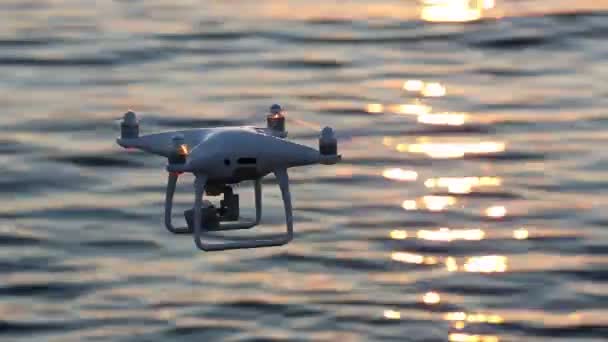 Remote controlled drone flying sparkle sunlight on sea — Stock Video