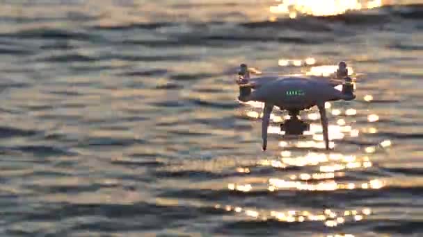 Remote controlled drone flying sparkle sunlight on sea — Stock Video