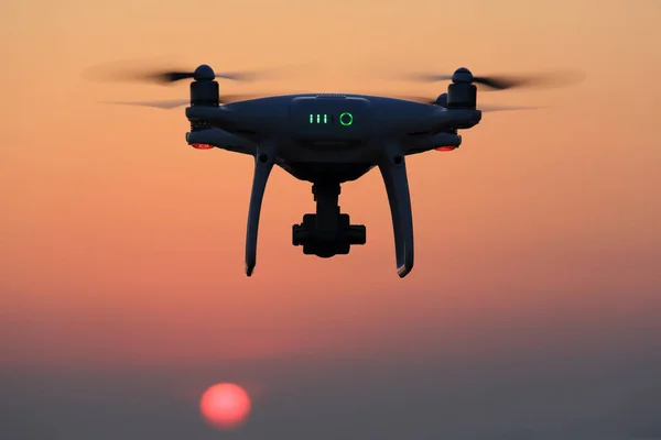 Drone telecomandato che vola nell'aria e nel cielo del tramonto — Foto Stock